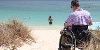Ein Mann im Rollstuhl am Strand